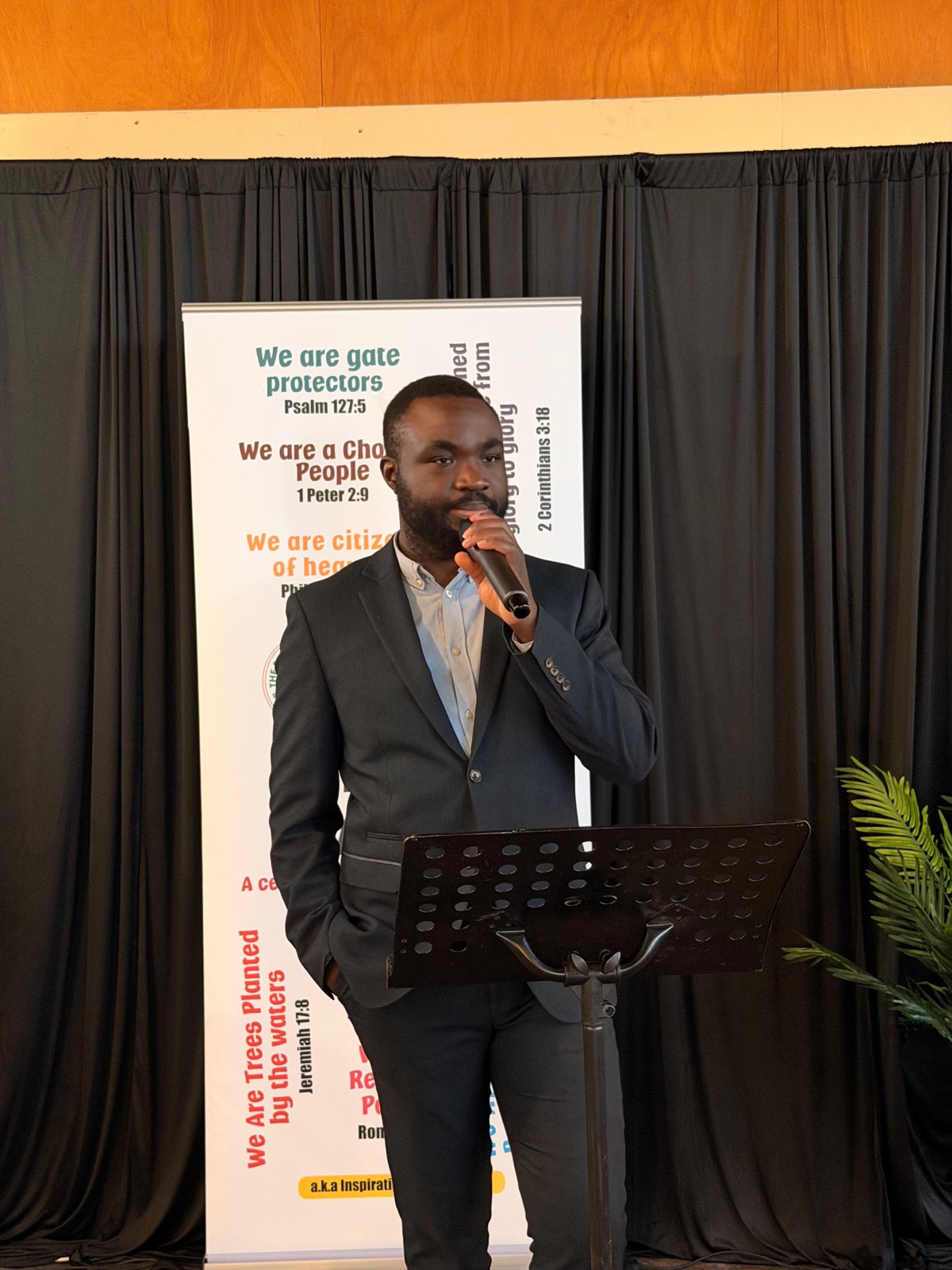 A young man in a suit preaching at the lectern