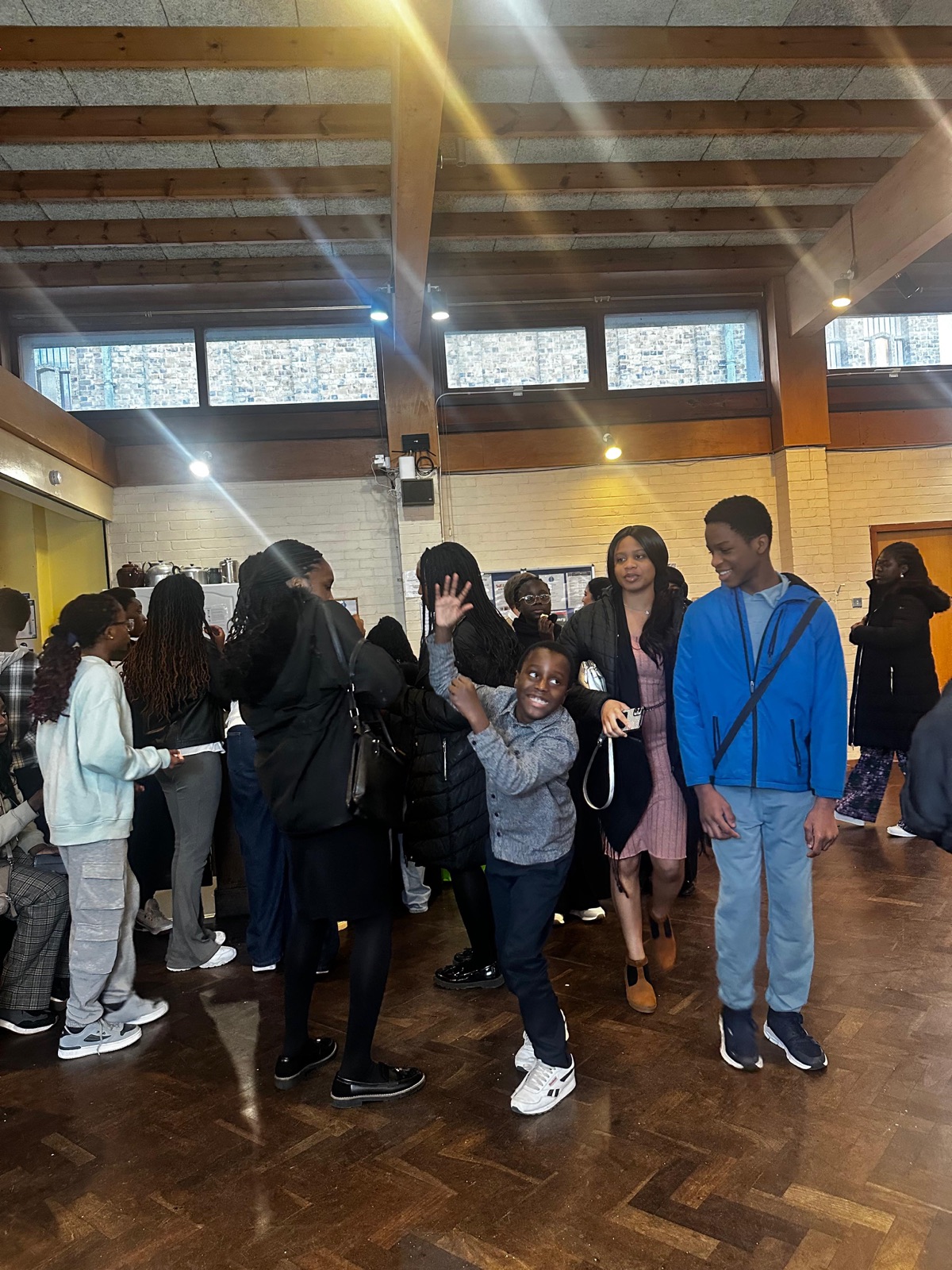 Young people laughing and dancing together in the hall after service