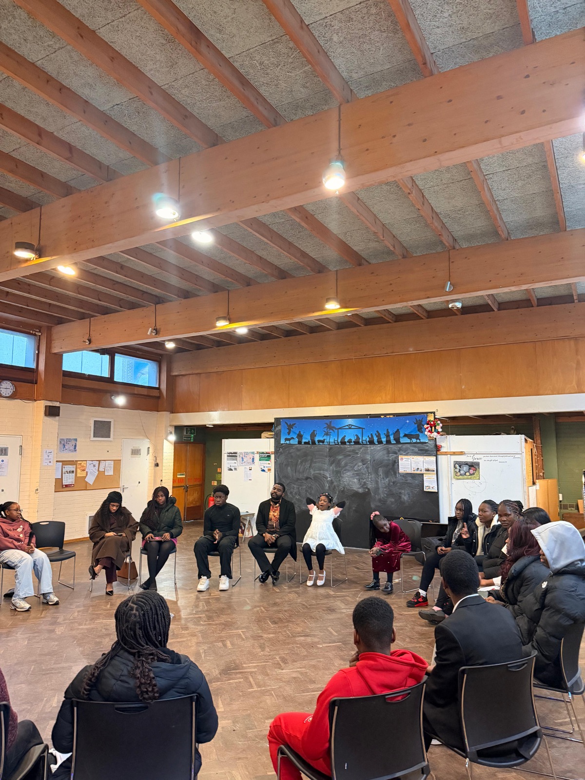 The congregation seated in a circle in the hall during a Sunday gathering